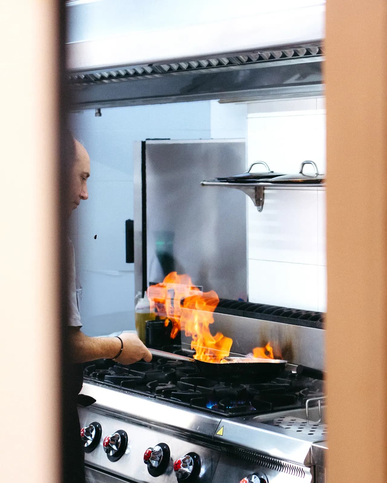 Chef Giancarlo Milano en cocina del Restaurante Già, flambé en sartén